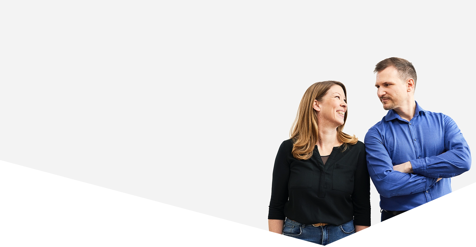 Mitarbeiterin und Mitarbeiter lächeln motiviert in die Kamera, Teamspirit bei Valean Solutions