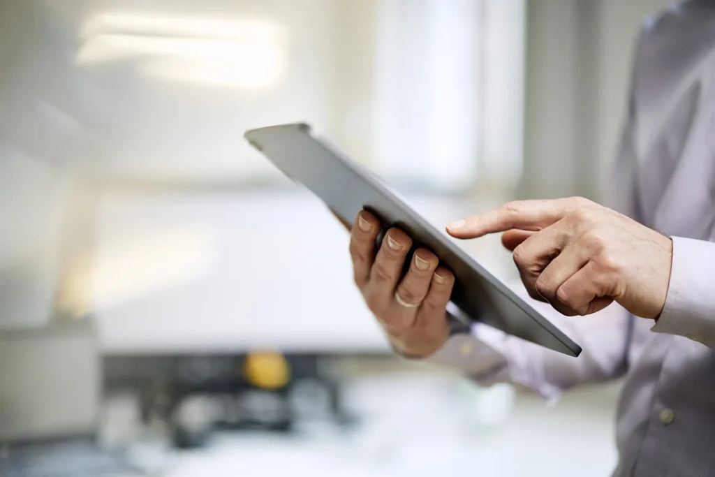 Mitarbeiter nutzt ein Tablet für Datenanalyse in einem modernen Arbeitsumfeld